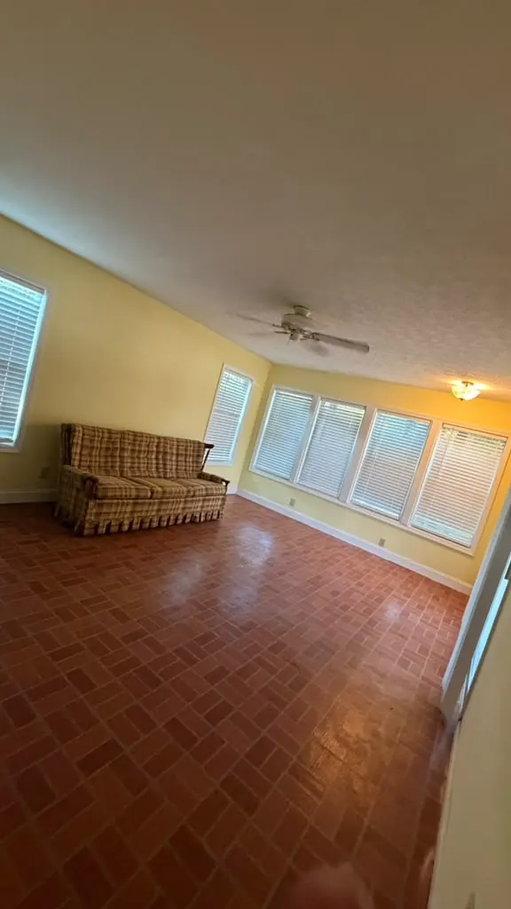 Empty living room with a clean, shiny brick floor