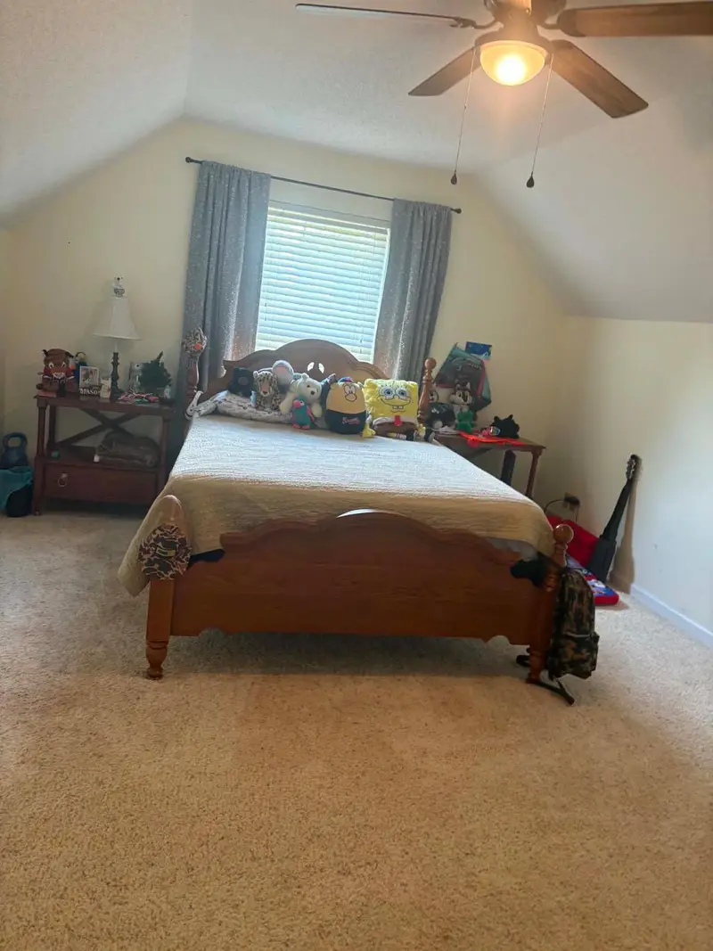 Bedroom with a clean carpet and a made bed